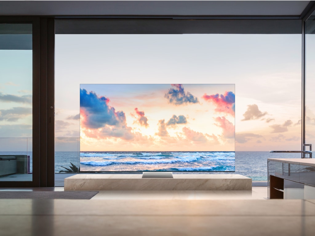 Samsung Neo QLED TV QN900D in front of a big glass window at sunset