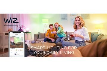 En familie sidder i en sofa og styrer lamperne via en app