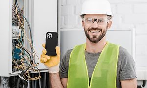Bygningsarbejder, der holder en telefon med Otterbox-dæksel