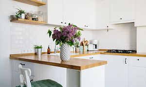 Et lille køkken med en vase på bordpladen