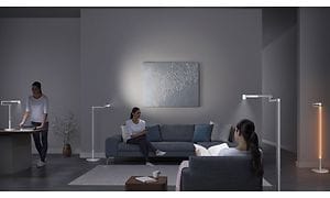 Den samme kvinde står og sidder rundt om i en stue med Dyson lys