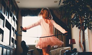 Pige i pink tøj danser i et rum