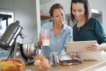 To kvinder der bruger en køkkenmaskine, mens de bager