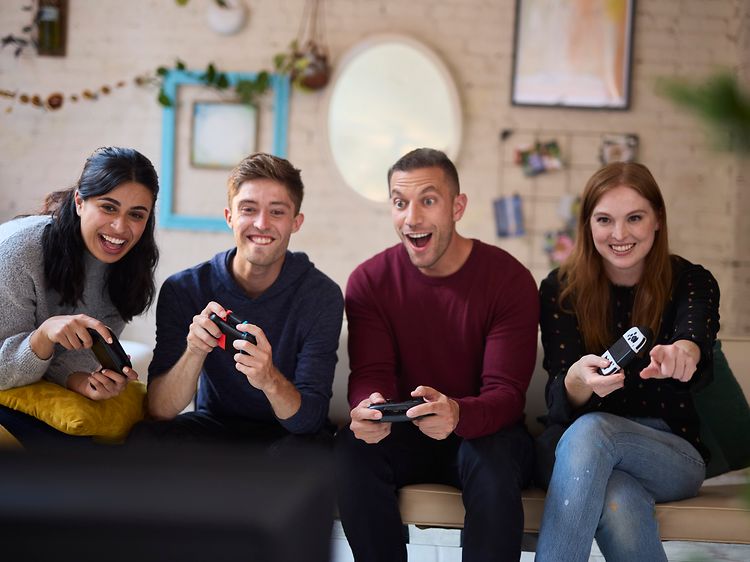 En gruppe venner har det sjovt mens de spiller Nintendo Switch sammen