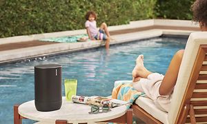 Sonos Move ved en pool på et bord ved siden af en kvinde