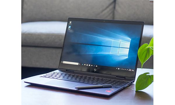 HP Envy x360 på et bord med en digital pen