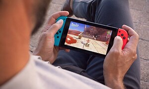 Nintendo Switch - mand, der holder enheden i hænderne, mens han spiller