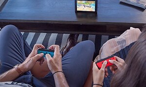 Nintendo Switch - to personer, der spillet med joy-controllere på enheden der står på bordet
