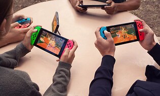 Nintendo Switch - fire personer, der spiller sammen med håndholdte enheder