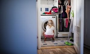 En pige, der kigger ind i en vaskemaskine