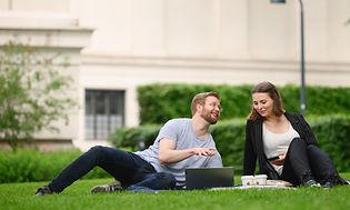 Mand og kvinde med laptop i en park