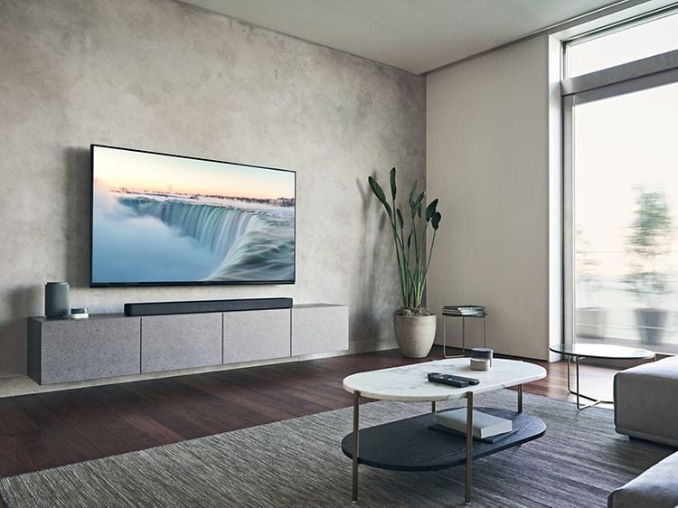 Sony HT-A7000 soundbar på et TV-møbel under et TV i en stue
