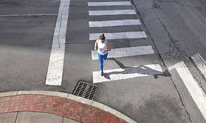 En kvinde der løber over et fodgængerfelt