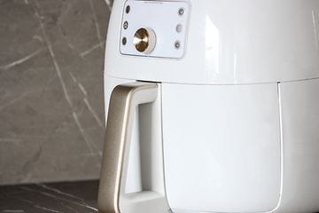 Nærbillede af en hvid airfryer på et køkkenbord