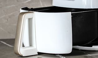 Nærbillede af en åben airfryer på et køkkenbord