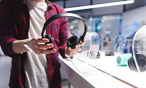 Mand i gang med at vælge høretelefoner i en butik