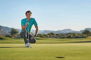 Billede af mand på knæ på en golfbane med en golfkølle i hånden
