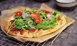 Billede af pizza med grøntsager på bagepapir