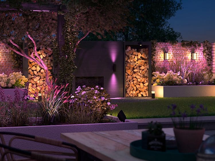Have og terrasse med ophængte lamper med lilla lys