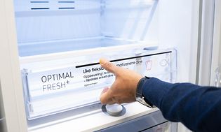 En mands hånd der åbner en skuffe i et køleskab