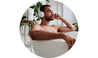 Mand der sidder i et badekar med hovedtelefoner på