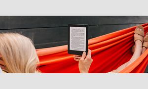 Kvinde ligger i en hængekøje med en Kobo e-bogslæser