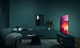Samsung OLED TV med høj lysstyrke og intense farver på skærmen, der lyser op i en mørkegrøn stue