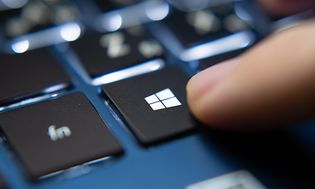 Person, der trykker på Windows-tasten på Microsoft Windows laptop-tastatur