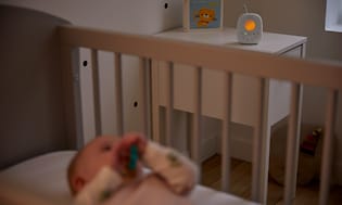 Philips Avent babyalarm på et værelse og en baby i en seng