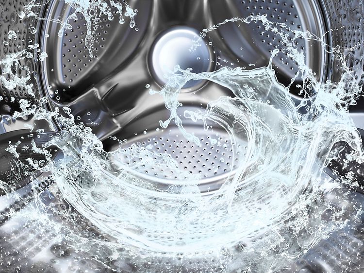 Vand, der danner en bølge inden i vaskemaskinens tromle