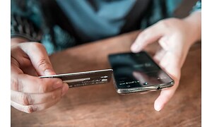 Smartphone og et kreditkort i hånd