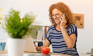 Kvinde der taler i telefon foran en computer