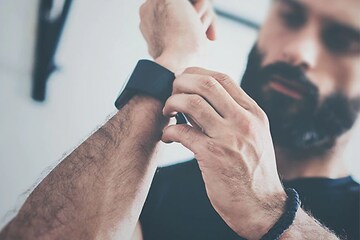 Mand der tilpasser remmen på hans smartwatch