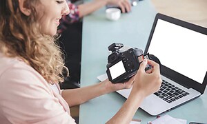 Woman inserting memory card in camera