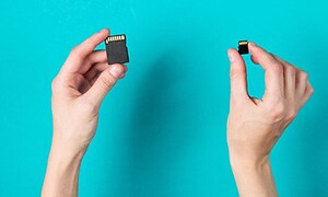 Person holding up two kinds of memory SD cards