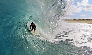 mand surfer på en stor bølge